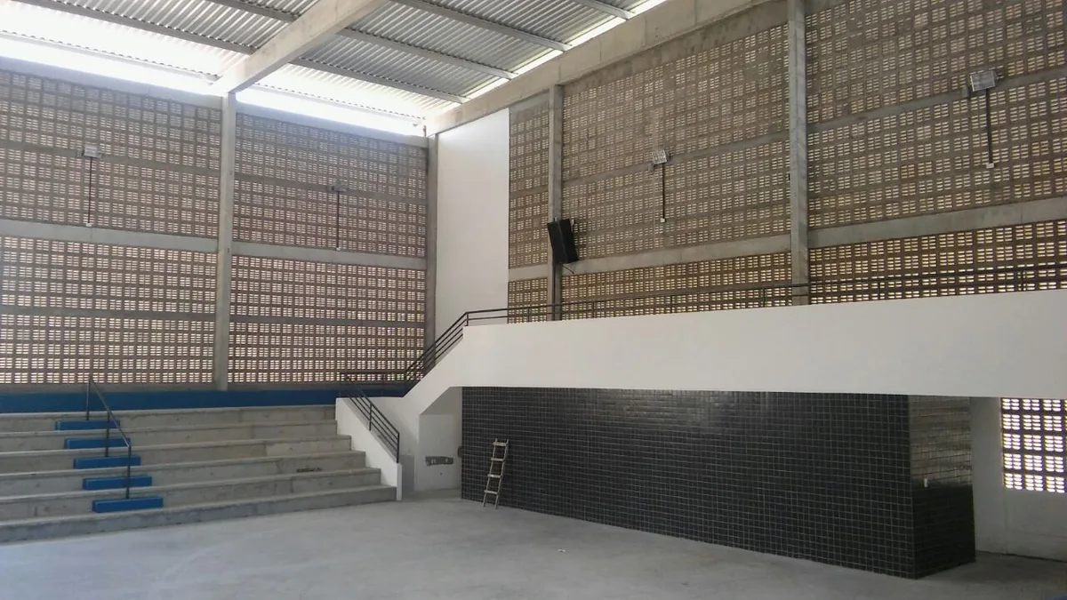 Ginásio com cobogós, arquibancadas e estrutura em concreto armado